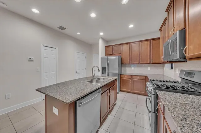 a kitchen that has a sink a stove and a refrigerator