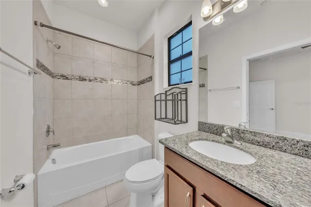 a bathroom with a granite countertop sink a toilet and shower