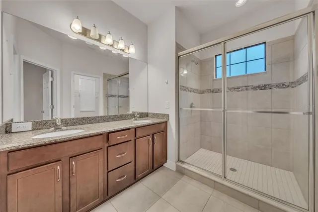 a bathroom with a shower sink and mirror