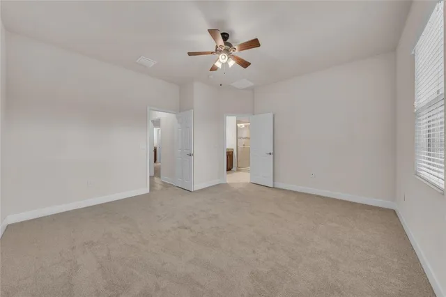 an empty room with closet and windows