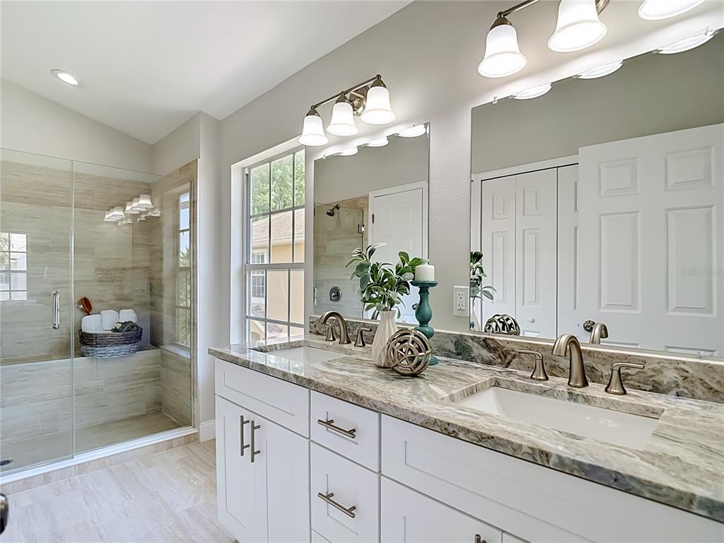 5310 Anhinga Trail New Port Richey, FL 34653 - Photo 17 of 27 a bathroom with a granite countertop sink a large mirror and a shower