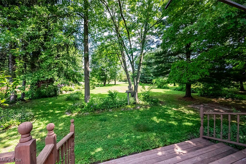349 Johnson Plank Road Warren, OH 44481 - Photo 10 of 31 View of green lawn featuring a wooden deck and view of wooded area