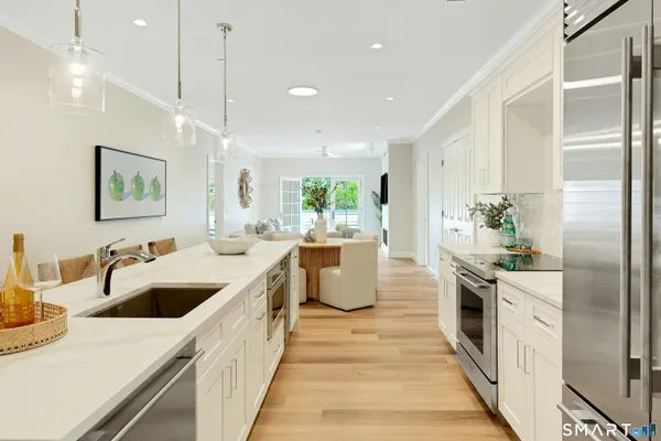 a large kitchen with kitchen island a large counter top a sink a stove and a refrigerator