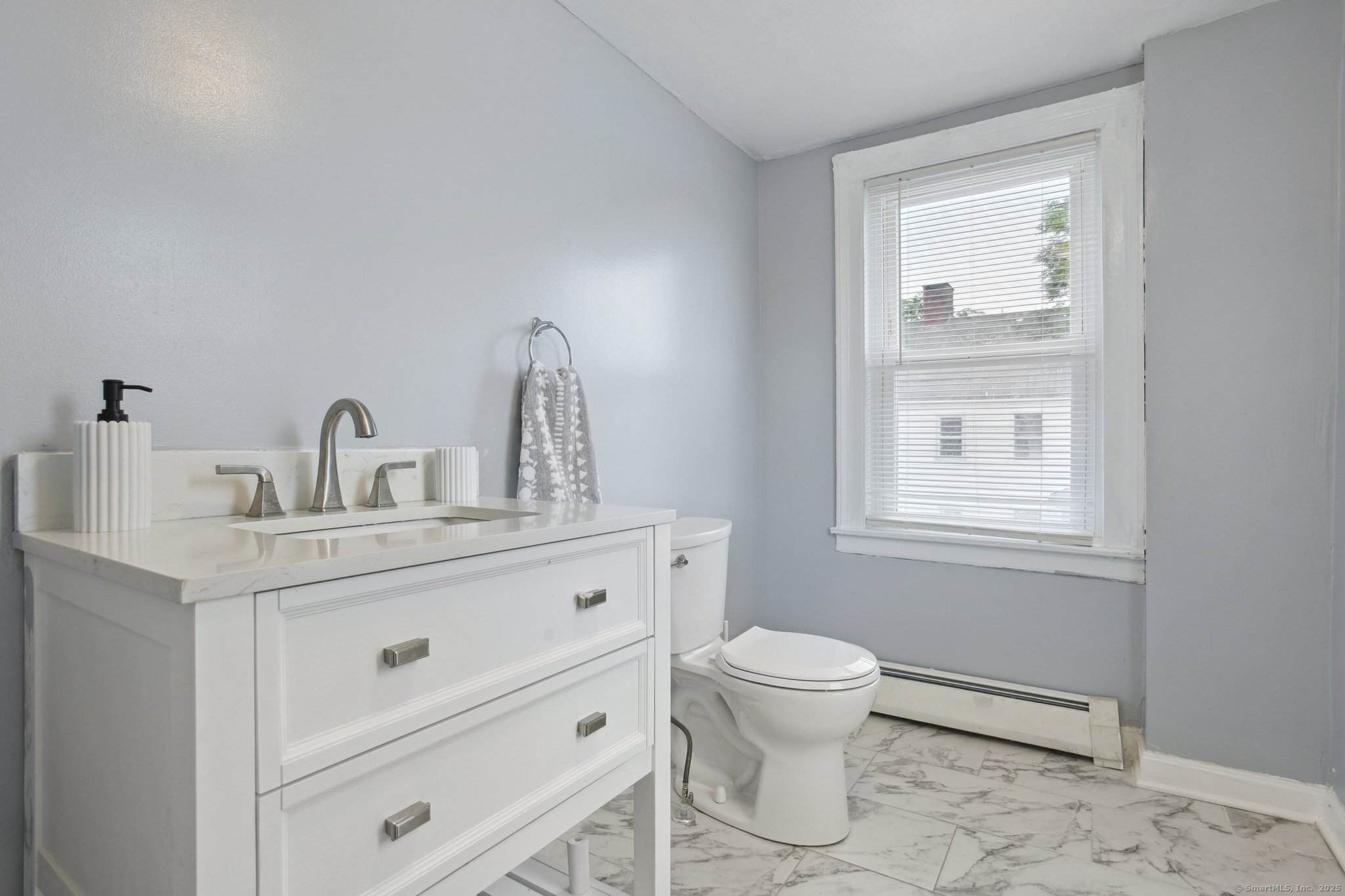 8 3rd Street Norwich, CT 06360 - Photo 12 of 39 a bathroom with a toilet a sink a mirror and a window