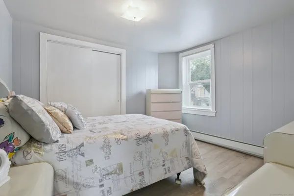 a bedroom with a bed and wooden floor