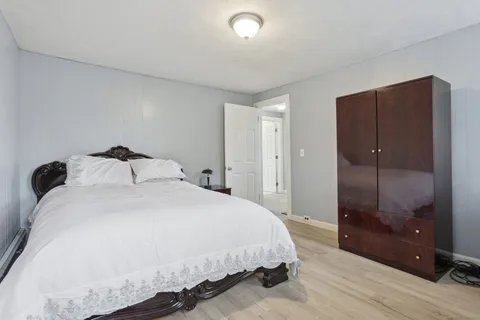 a bedroom with a bed and a glass door shower