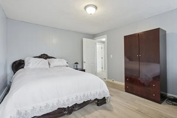 a bedroom with a bed and a glass door shower