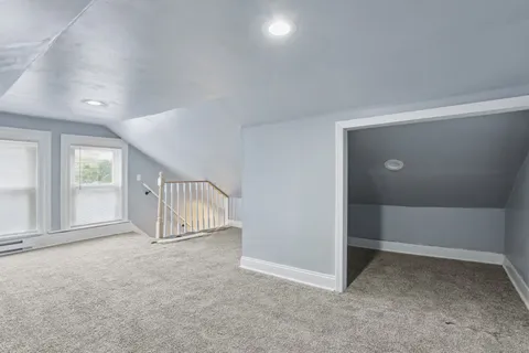 an empty room with staircase and closet area