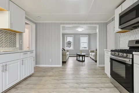 a view of a kitchen with a sink cabinets and wooden floor