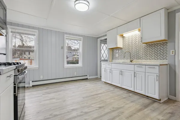 a view of a kitchen with wooden floor and electronic appliances