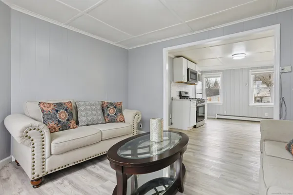 a living room with furniture and view of kitchen