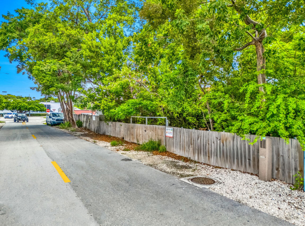 a view of a street with wooden fence