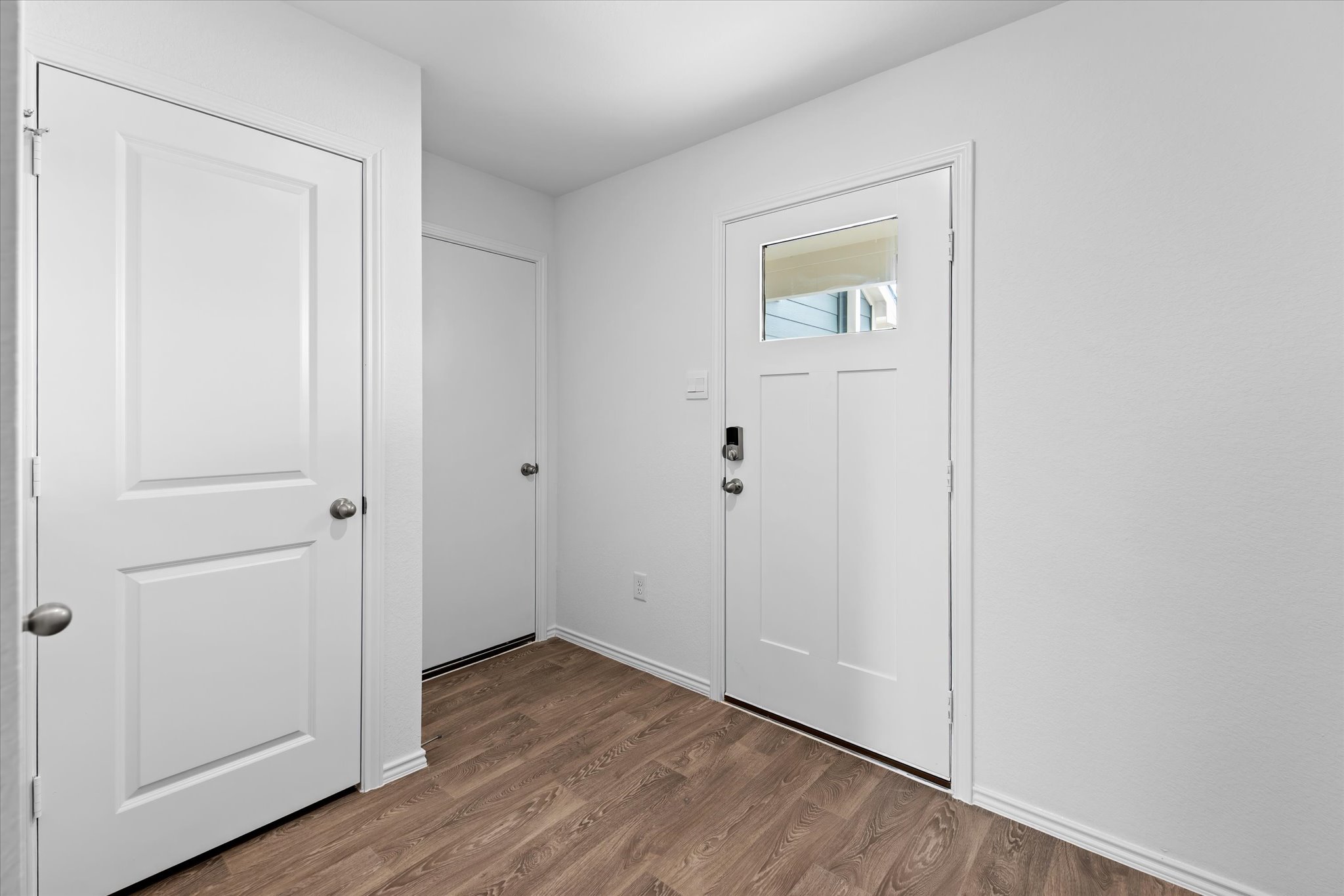 456 Sandringham Loop Kyle, TX 78640 - Photo 23 of 40 A well-maintained entryway featuring warm wood flooring and bright white doors.