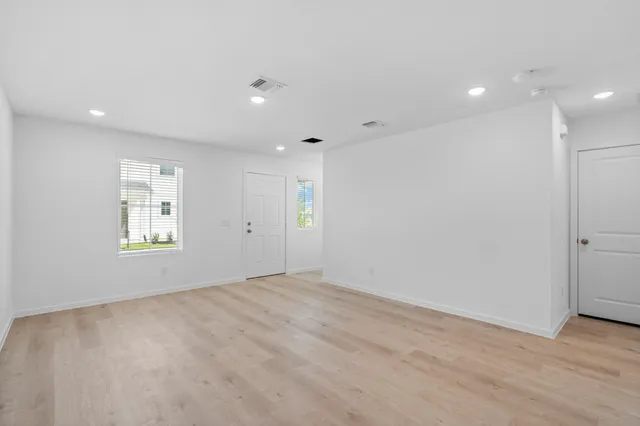 a view of a kitchen with a sink and dishwasher a refrigerator with white cabinets