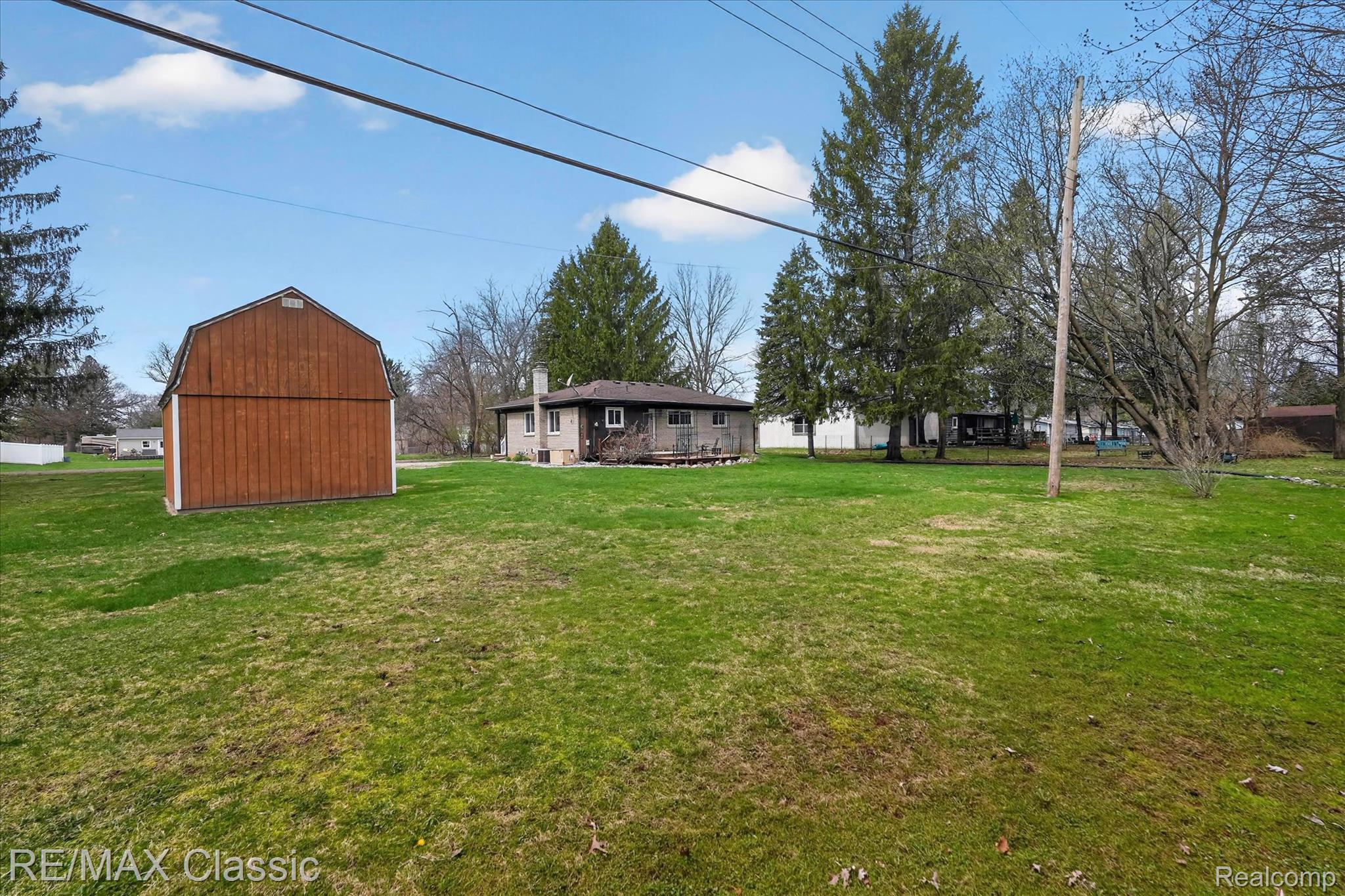 5060 Warmbriar Road White Lake, MI 48383 - Photo 26 of 34 View of grassy yard featuring a barn and an outdoor structure