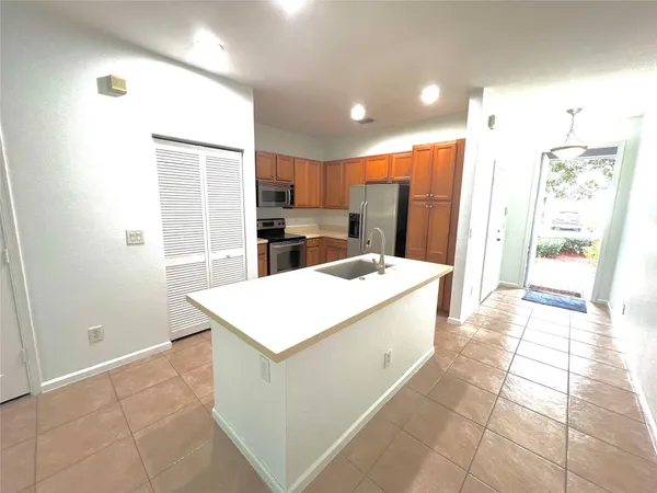 a large kitchen with kitchen island a sink a stove a refrigerator and a cabinets