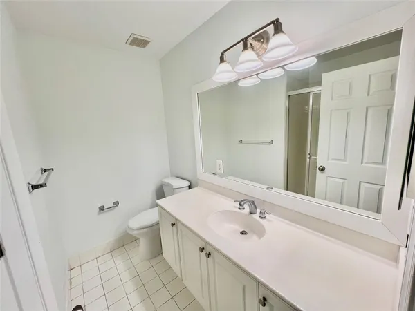 a bathroom with a sink vanity mirror and toilet