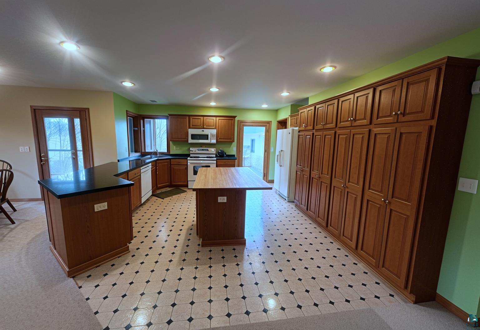 502 Spring Creek Circle Baraboo, WI 53913 - Photo 9 of 26 Kitchen featuring extensive wood cabinetry, patterned tile flooring, recessed lighting, and a central island with a wood countertop