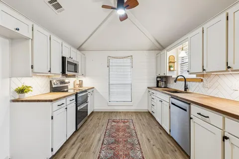 a kitchen with stainless steel appliances granite countertop a stove sink and cabinets