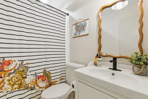 a bathroom with a sink a toilet and mirror