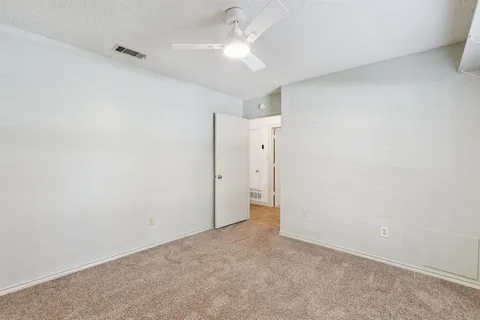 an empty room with a ceiling fan and a fan