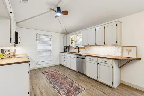 a kitchen with granite countertop a sink stainless steel appliances and cabinets