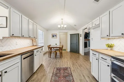 a kitchen with granite countertop a sink appliances cabinets and counter space