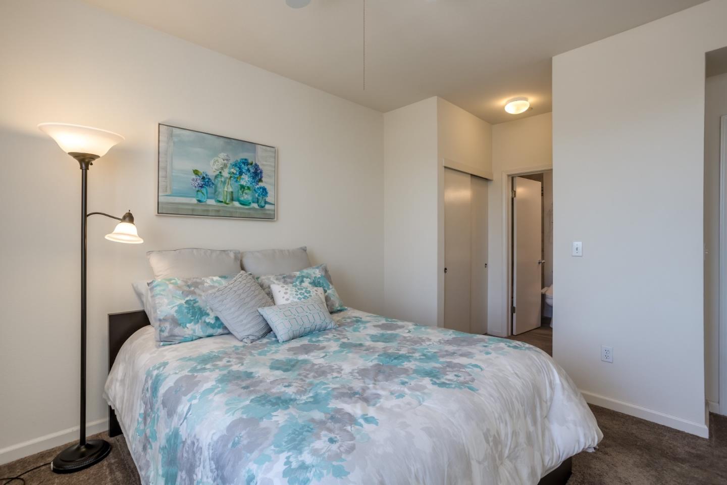 614 Arcadia Terrace, Unit 206 Sunnyvale, CA 94085 - Photo 12 of 21 a large bed sitting in a bedroom and a chandelier
