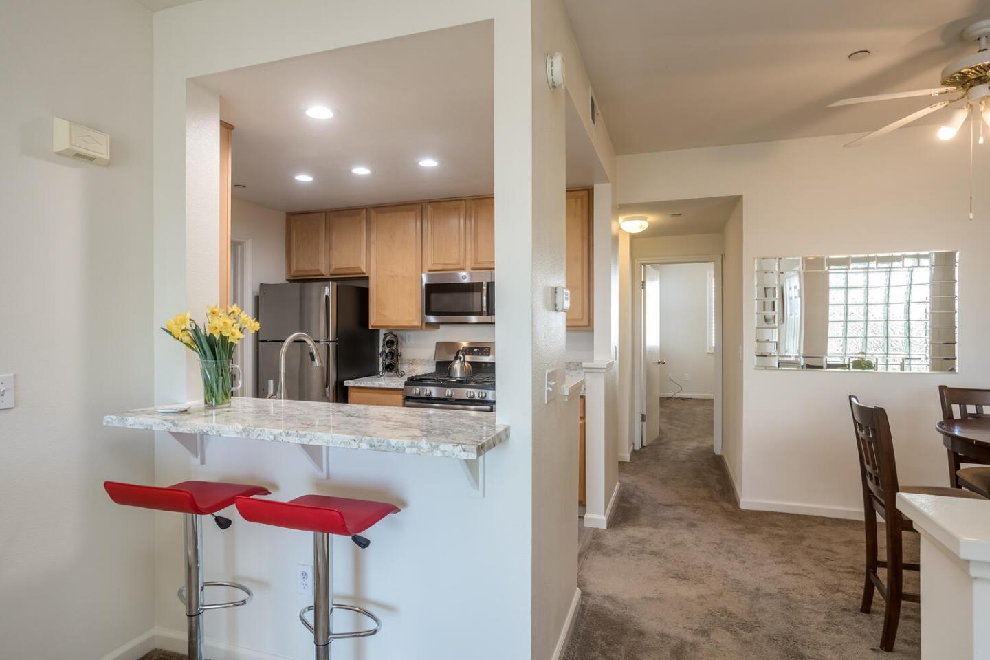 614 Arcadia Terrace, Unit 206 Sunnyvale, CA 94085 - Photo 6 of 21 a kitchen with stainless steel appliances kitchen island granite countertop a refrigerator and a dining table