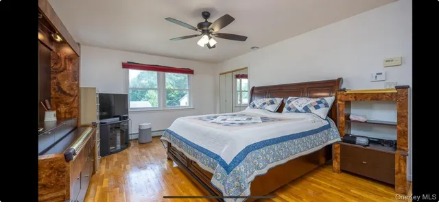 a bedroom with a bed and a flat tv screen on dresser