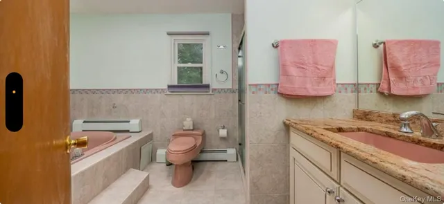 a bathroom with a granite countertop toilet sink and mirror