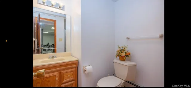 a bathroom with a toilet sink vanity and mirror