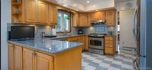 a kitchen with stainless steel appliances granite countertop a stove a sink and a microwave