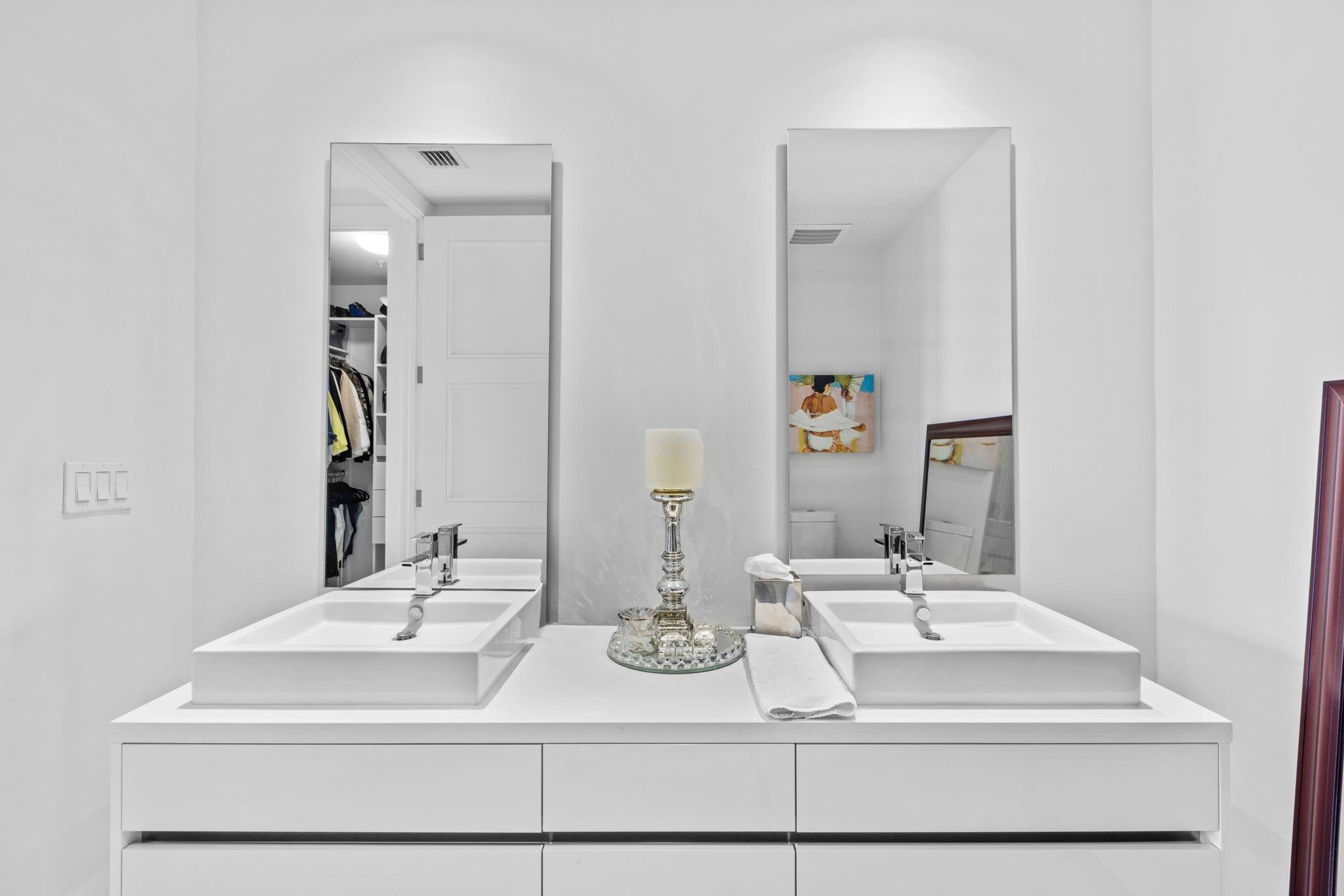 155 East Boca Raton Road, Unit 417 Boca Raton, FL 33432 - Photo 13 of 29 a bathroom with double vanity sinks and a mirror
