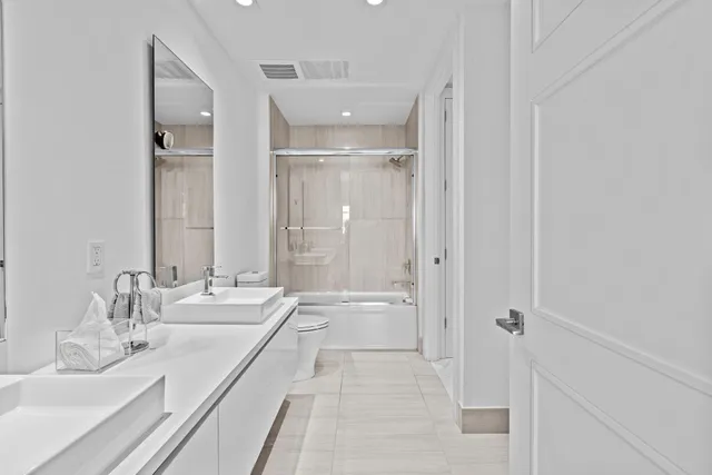 a bathroom with a granite countertop sink mirror and a bathtub