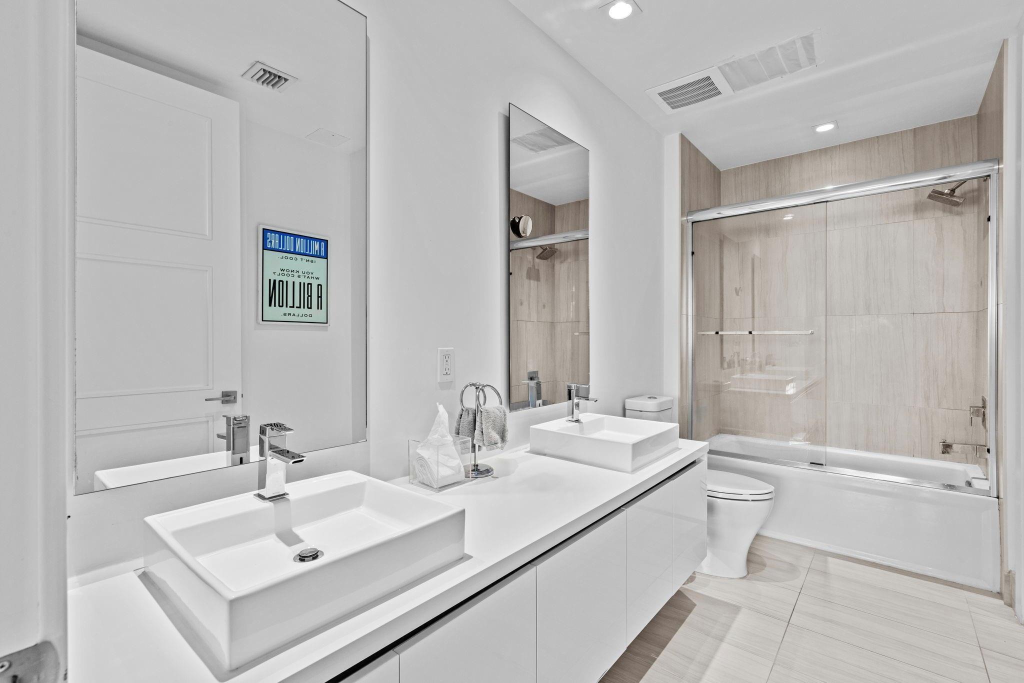 155 East Boca Raton Road, Unit 417 Boca Raton, FL 33432 - Photo 18 of 29 a bathroom with double vanity sinks double vanity tub and shower