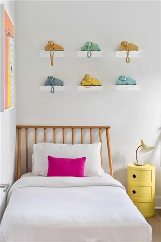 a bedroom with a bed and painting on the wall