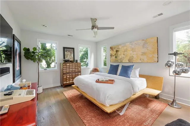 a bedroom with a bed wooden floor and window