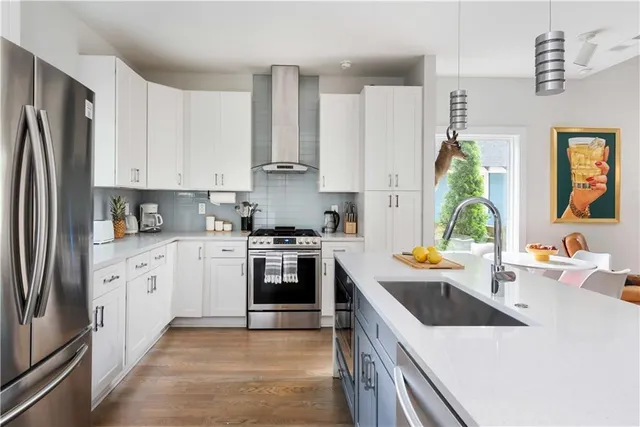 a kitchen with white cabinets and white appliances