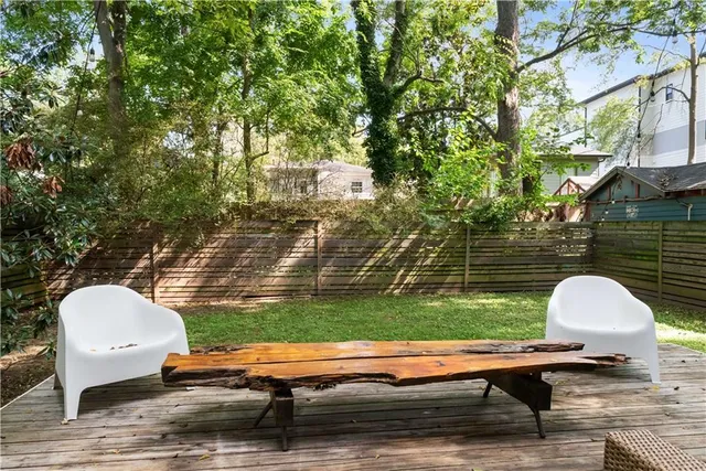 a view of backyard with table and chairs and wooden fence