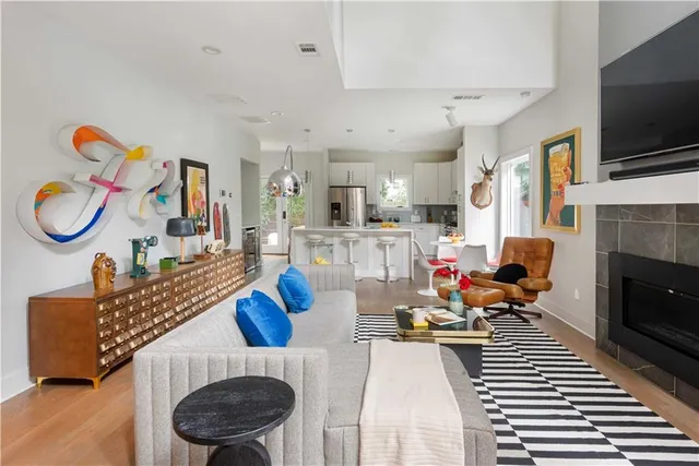 a living room with furniture a flat screen tv and kitchen view
