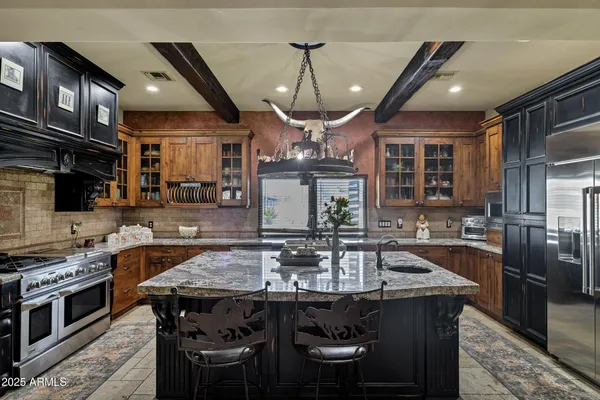 a kitchen with stainless steel appliances granite countertop a sink stove and cabinets