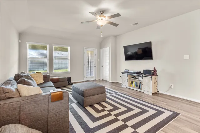 a living room with furniture a flat screen tv and a large window