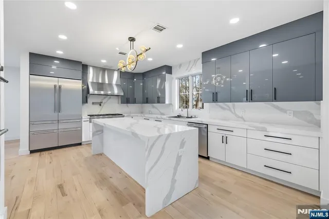a large kitchen with kitchen island a sink stainless steel appliances and cabinets