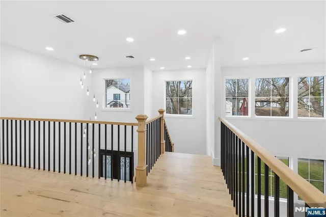 a view of hallway with wooden floor and windows