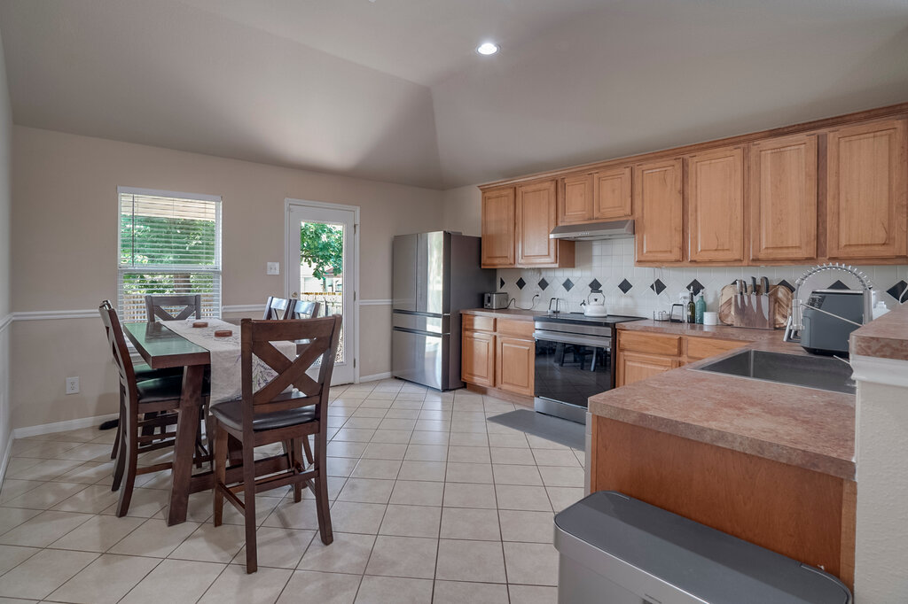 2724 Kickapoo Cavern Drive Pflugerville, TX 78660 - Photo 9 of 24 A functional kitchen with light wood cabinetry and a casual dining area for everyday meals.