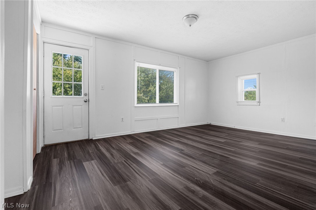 2387 29th Street Southwest Akron, OH 44314 - Photo 15 of 24 Spare room featuring dark wood-style flooring and a decorative wall