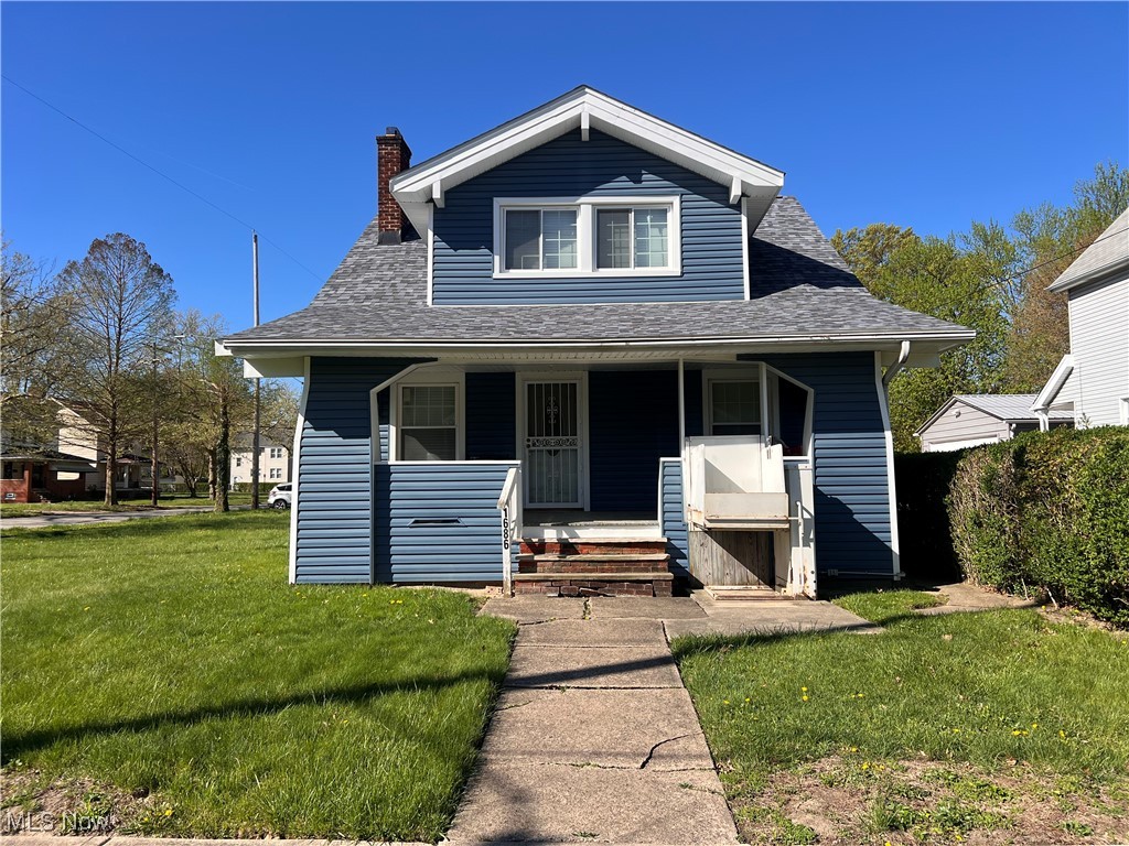 Bungalow-style house with covered porch, roof with shingles, a chimney, and a front yard
