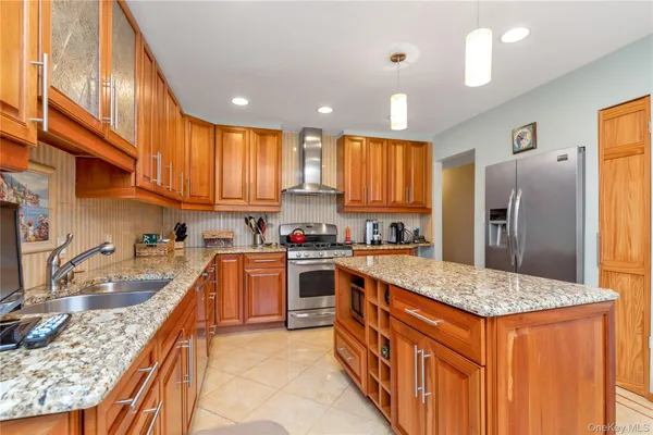 a kitchen with stainless steel appliances granite countertop a sink stove and refrigerator