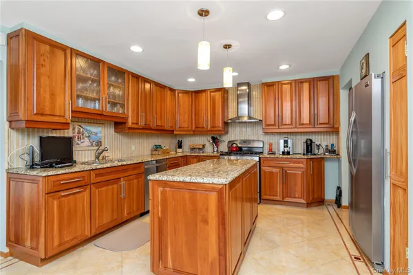 a kitchen with stainless steel appliances granite countertop wooden cabinets a sink and a stove